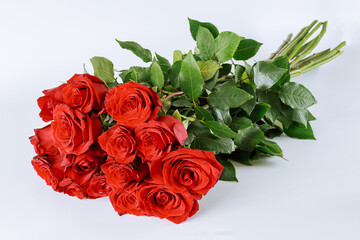 Bouquet of red roses with lush green leaves on a white background