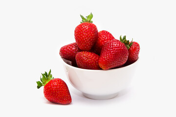 Red ripe large strawberries in a white cup or bowl on a white background. Close-up. Place to insert.
