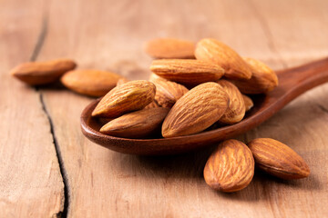 side view Select focus  peeled almond in wood spoon wood table almond Nuts Ready to use with advertising text
