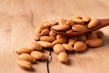 side view Select focus  peeled almond in wood spoon wood table almond Nuts Ready to use with advertising text