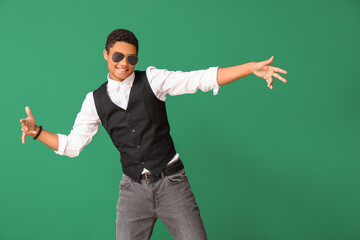 African-American teenager dancing against color background