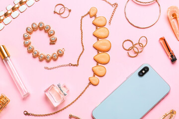 Beautiful jewelry with mobile phone and female accessories on color background