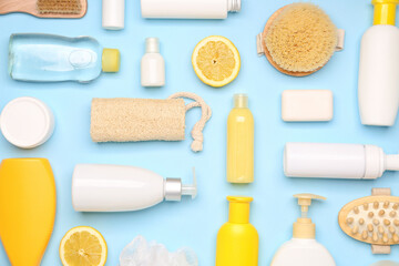 Shower gels with bath supplies on color background