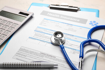 Health insurance form with stethoscope and calculator on table
