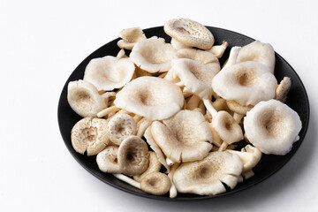 fresh whole mushrooms in a dish on white background