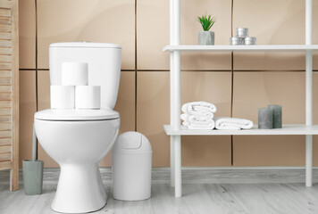 Fototapeta na wymiar Toilet bowl and rolls of paper in restroom