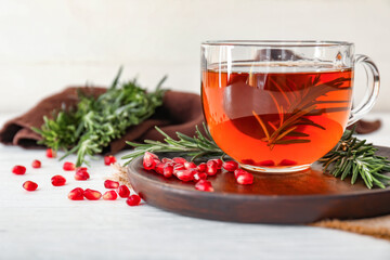 Cup of hot tea with rosemary on table