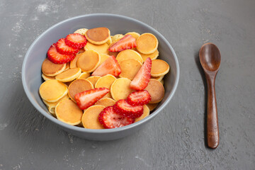 Tasty pancake breakfast with strawberries in a gray bowl