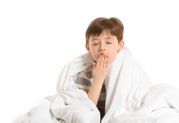 Yawning little boy wrapped in blanket on white background