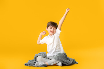 Little boy with plaid on color background