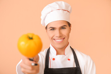 Transgender chef with tomato on color background