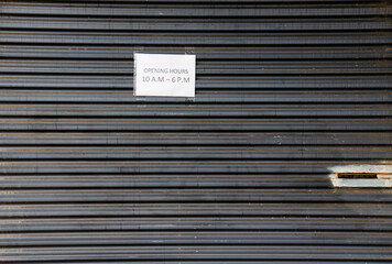 shutter door with opening hours sign