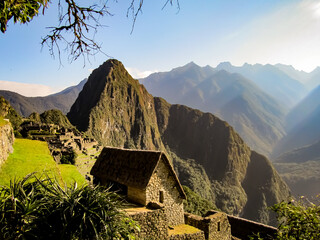 Panoramic view of the Machu Picchu. Old stone house with palm roof in Machu Picchu, ancient Inca city located in Urubamba, Peru.