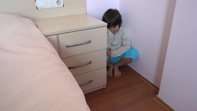4K Punished child sits in the corner and smile

