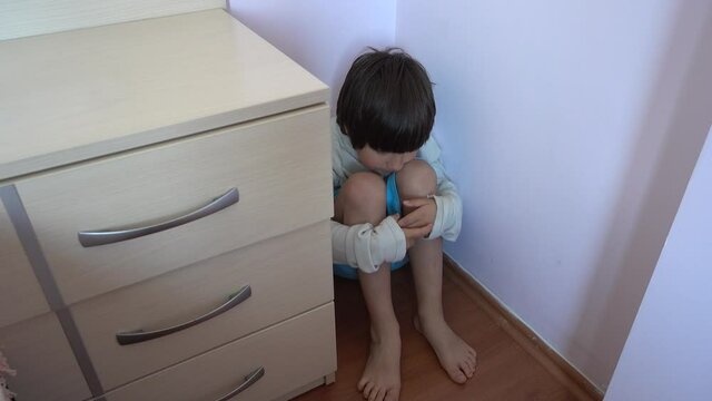 4K Punished child is bored sitting in the corner
