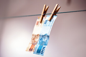 100 and 50 reais bank note on the drying line. Dirty money being laundered, concept of corruption in brazil