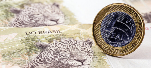 fifty reais bill with one real coin. Brazilian ounce printed with 1 real coin. Brazil economy concept. © RHJ