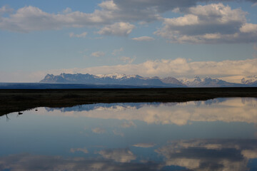 Fototapeta premium Snow covered mountains reflected in a shallow lake in Iceland