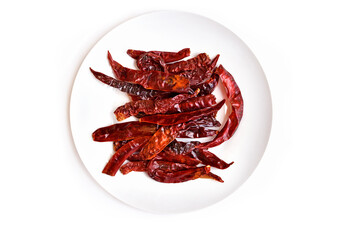 Red dried chili peppers on white plate