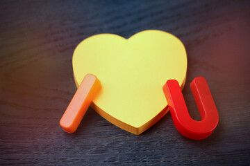 Letters I and U with a blank symbolic heart shaped sticker. Short Message I love you