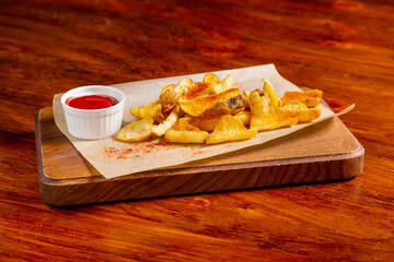 Potato chips with red sauce, ketchup, beer snack in a plate on the table
