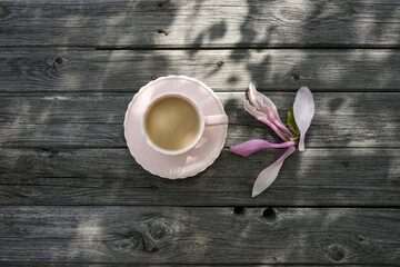 Pink magnolia flower and a mug with a drink