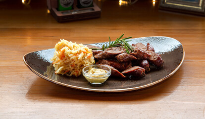 Fried sausages with slices of cabbage on a plate. Beer snack on the table.