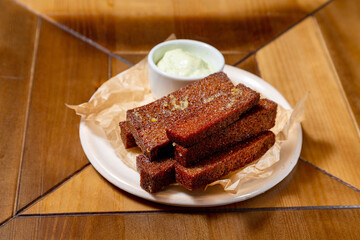 Brown bread croutons in a plate, a beer snack at home or in a cafe
