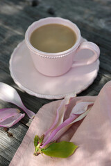 Pink magnolia flower and a mug with a drink