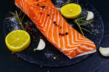 Raw salmon fillet with spices on black slate