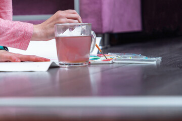 Cute young girl draws a poster on the floor.