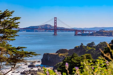 Photo sur Plexiglas Pont du Golden Gate View of the Golden Gate bridge from Lands End cliffs with cypress trees, Pacific Ocean in background in San Francisco CA