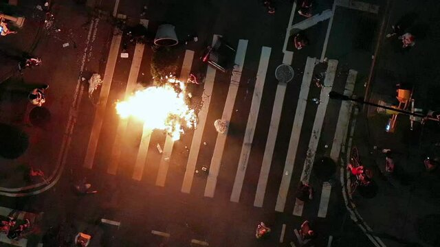 protestors burning fire in intersection on street at night in New York City NYC