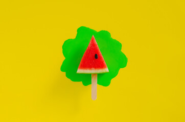 Red slice watermelon design as ice cream with stick that have green poster color drop on yellow...
