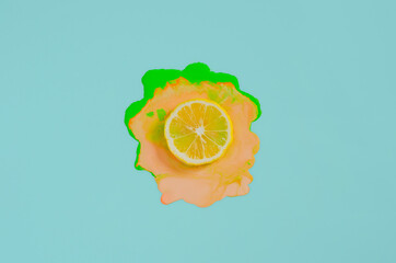 Slice lemon on colorful poster color that drop on blue background. Minimal summer concept.