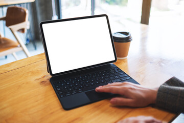 Mockup image of a businesswoman using and touching on tablet touchpad with blank white desktop screen as computer pc with coffee cup on the table