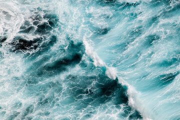 Fototapeta na wymiar Blue and white wave creating ocean pattern, aerial perspective.