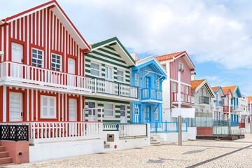 Fototapeta na wymiar Street with colorful striped houses, Costa Nova, Aveiro, Portugal. Facades of colorful fisheman houses in Costa Nova, Aveiro, Portugal