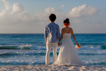 Fototapeta na wymiar A man and a woman walk on the seashore and look at the horizon.