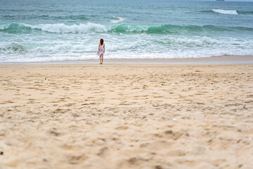 Relaxed woman enjoying ocean, freedom and life at beach. Young lady feeling free, relaxed and happy. Concept of freedom, happiness, enjoyment and well being.