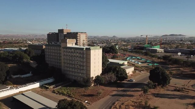 4K aerial drone summer sunny day video of Windhoek Katutura suburb large state hospital near B1 main highway in Namibia's capital in central highland Khomas Hochland of Namibia, southern Africa