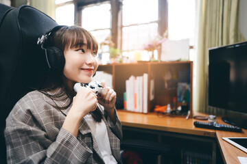 Asian teenager woman stay at home and play a game console online.