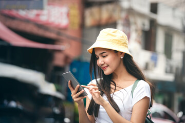 Asian traveller young adult woman use smart phone in Bangkok city