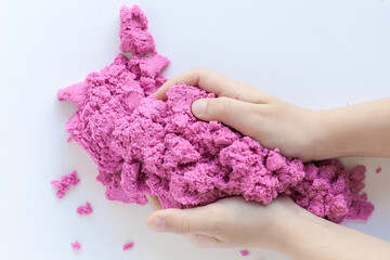 hands on the background of kinetic sand. construction of turrets. children's creativity.