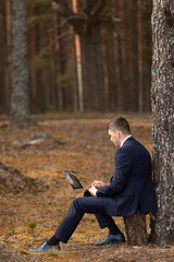 Fototapeta premium freelancer with laptop working in forest