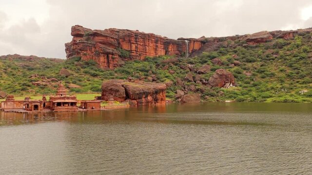 Pan view of amazing Bhutanatha group of temples and hill cliffs at Badami during Monsoon with Waterfall created due to heavy rain near the Bhutanatha temple at Badami cliffs.