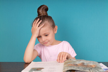 Sad tired frustrated girl sitting at the table with many books. Learning difficulties, education concept.