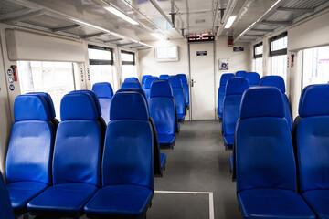 Fototapeta premium The interior of the transfer train to the airport. Rows of blue armchairs. Without people