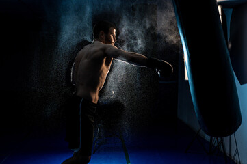 Sportsman boxer fighting on black background with smoke. Boxing sport concept. Shadow fight