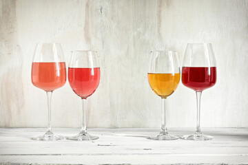 Assorted different wines in glasses on a white wooden table. Wine tasting concept. Copy space.